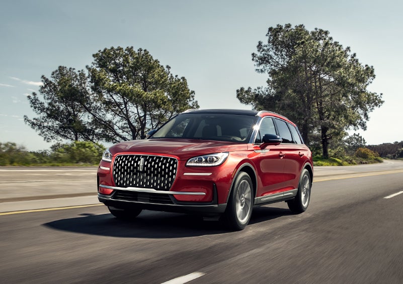 A 2024 Lincoln Corsair® SUV is shown being driven on a country road. | Varsity Lincoln in Novi MI