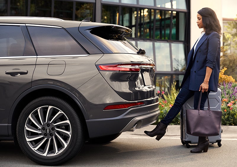 A woman with her hands full uses her foot to activate the available hands-free liftgate. | Varsity Lincoln in Novi MI