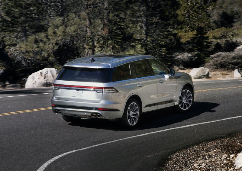 A 2023 Lincoln Aviator® Grand Touring model is shown being driven on a tight turn of a mountain road | Varsity Lincoln in Novi MI