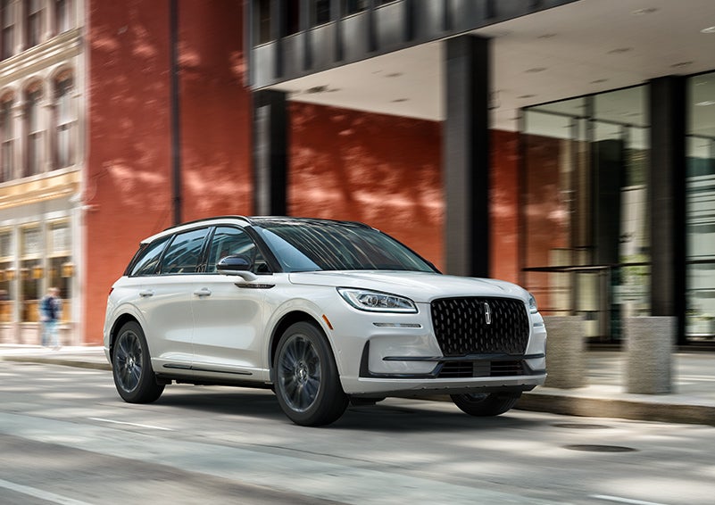 The 2024 Lincoln Corsair® SUV with the Jet Appearance Package and a Pristine White exterior is parked on a city street. | Varsity Lincoln in Novi MI