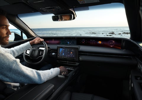 A driver of a parked 2024 Lincoln Nautilus® SUV takes a relaxing moment at a seaside overlook while inside his Nautilus. | Varsity Lincoln in Novi MI