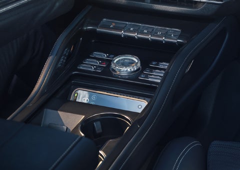 A smartphone is shown charging in the wireless charging pad. | Varsity Lincoln in Novi MI
