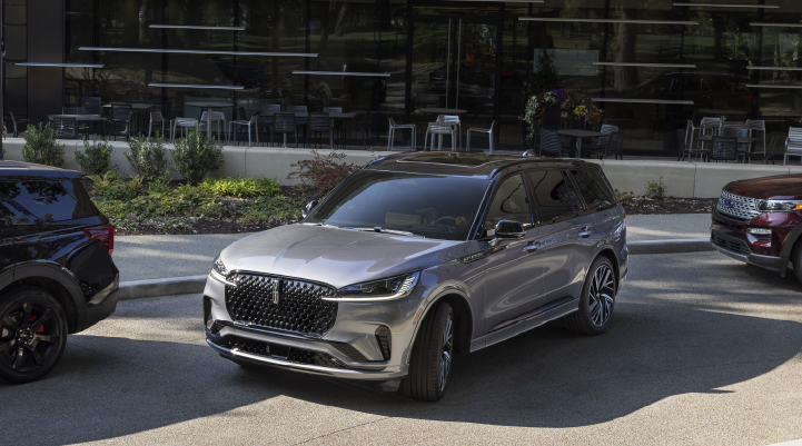 A gray 2025 Lincoln Black Label Aviator® SUV is shown in the process of parallel parking. | Varsity Lincoln in Novi MI