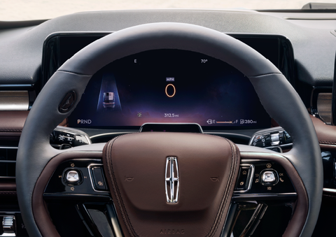 The steering wheel of 2025 Lincoln Aviator® SUV is shown with black and brown accents. | Varsity Lincoln in Novi MI