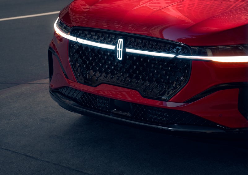 The available front LED light bar and center Lincoln Star logo glow at dusk. | Varsity Lincoln in Novi MI