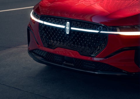 The available front LED light bar and center Lincoln Star logo glow at dusk. | Varsity Lincoln in Novi MI