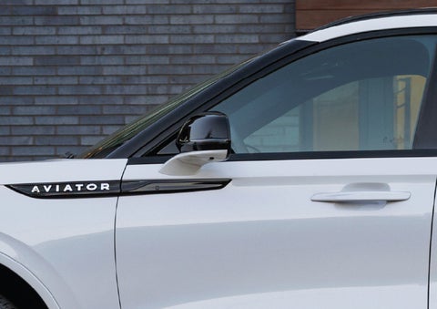 The driver’s side door and fender badging of a white 2026 Lincoln Aviator® SUV are showcased. | Varsity Lincoln in Novi MI