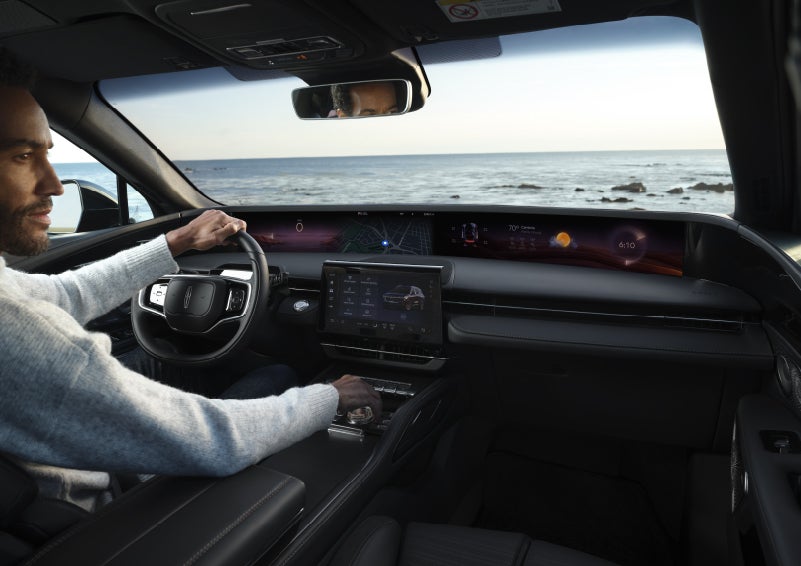 A driver of a parked 2026 Lincoln Nautilus® SUV takes a relaxing moment at a seaside overlook while inside his Nautilus. | Varsity Lincoln in Novi MI