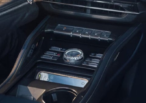 A smartphone is shown charging in the wireless charging pad. | Varsity Lincoln in Novi MI