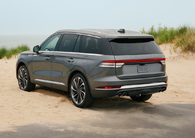 A 2027 Lincoln Aviator® SUV is parked next to sand dunes. | Varsity Lincoln in Novi MI