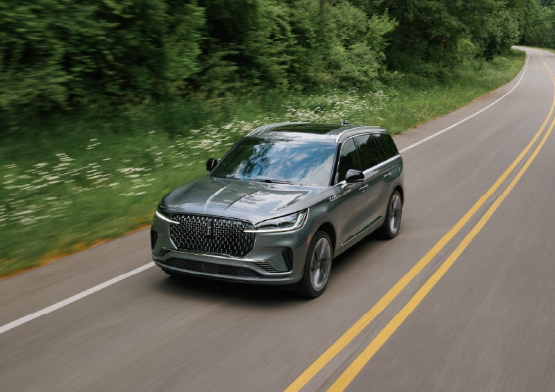 A 2027 Lincoln Aviator® SUV is being driven down a road. | Varsity Lincoln in Novi MI