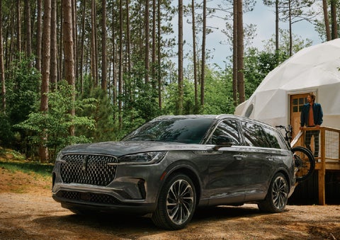A 2027 Lincoln Aviator® is parked next to a high end glamping site. | Varsity Lincoln in Novi MI