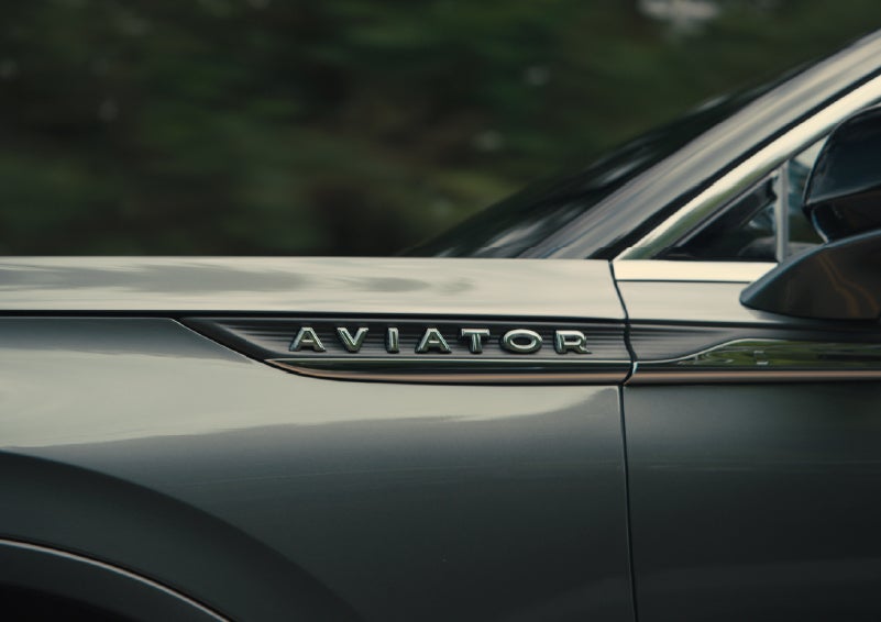 The driver’s side door and fender badging of a gray 2027 Lincoln Aviator® SUV are showcased. | Varsity Lincoln in Novi MI