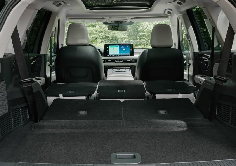A rear to front view of the interior of a 2027 Lincoln Aviator® Black Label™ SUV shows the third and second rows folded flat | Varsity Lincoln in Novi MI