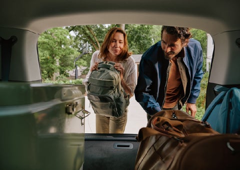 A couple loads luggage into the rear of a 2027 Lincoln Aviator® Black Label™ SUV..e 202 | Varsity Lincoln in Novi MI