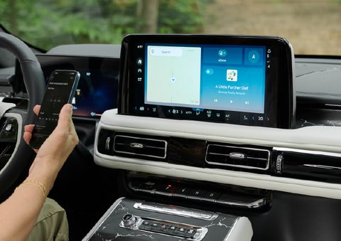 A person pairs thier phone with the center touchscreen of a 2027 Lincoln Aviator® Black Label™ SUV | Varsity Lincoln in Novi MI
